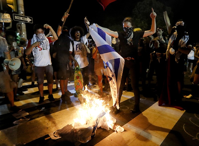 
              Demonstrators burn a flag during a protest in Philadelphia, Tuesday, July 26, 2016, during the second day of the Democratic National Convention. (AP Photo/John Minchillo)
            