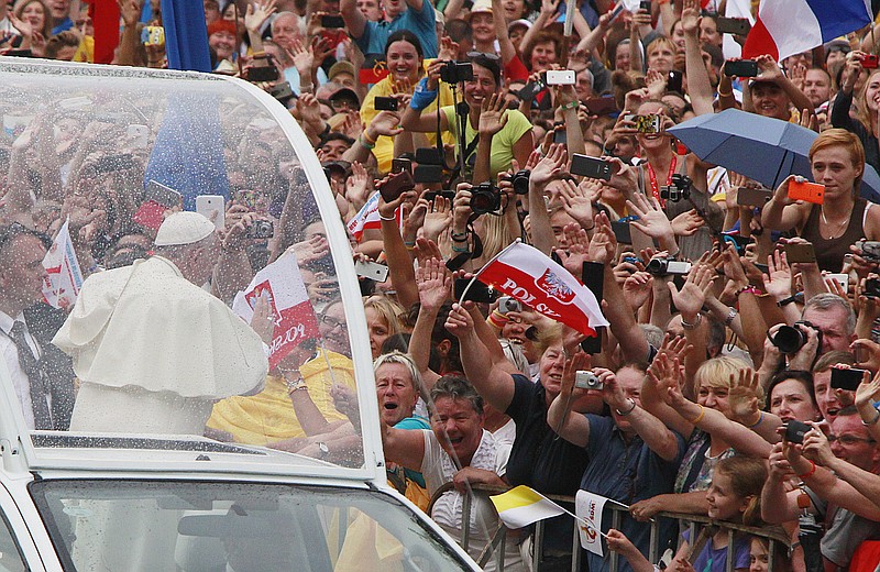 Pope Francis salutes faithful and pilgrims on his way to the royal Wawel Castle in Krakow, Poland, Wednesday, July 27, 2016. Pope Francis has been greeted in Poland by President Andrzej Duda and hundreds of singing and cheering people as he arrived at the airport in Krakow. (AP Photo/Czarek Sokolowski)