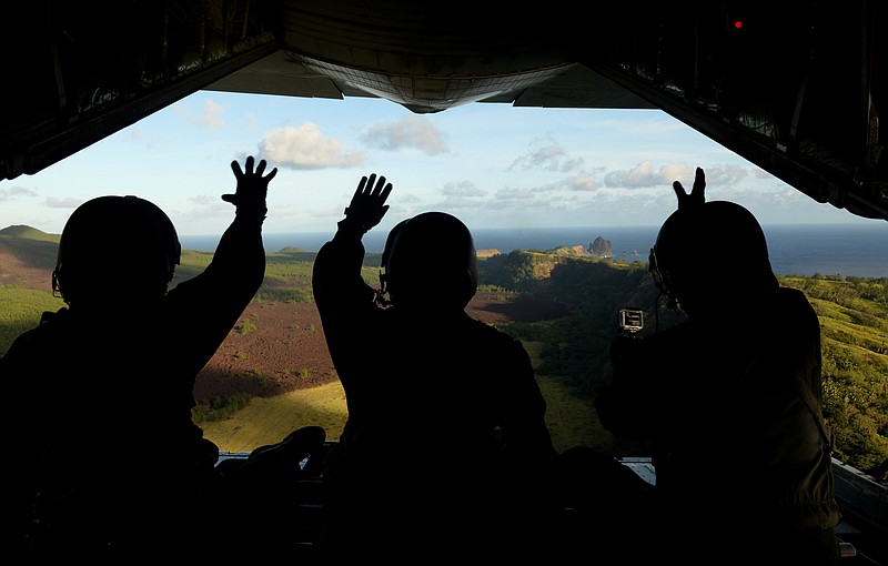 
              FILE - In this Dec. 9, 2015 file photo provided by the U.S. Air Force, Japan Air Self-Defense Force airmen wave at residents of Pagan island in the Commonwealth of the Northern Mariana Islands after dropping a package to the islanders as part of Operation Christmas Drop. Community members and an environmental group on Wednesday, July 27, 2016, sued the U.S. Navy, the Department of Defense and the secretary of defense over a plan to turn two Pacific islands, including Pagan, into live-fire testing sites.  (Staff Sgt. Benjamin Gonsier/U.S. Air Force via AP)
            