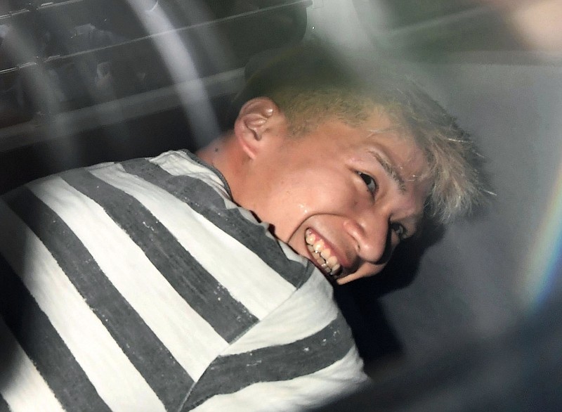 Satoshi Uematsu, the suspect of Tuesday's knife attack at a home for the mentally disabled, sits inside a police van as he leaves a police station in Sagamihara, outside Tokyo to be sent to prosecutors Wednesday, July 27, 2016. The deadliest mass killing in Japan in the post-World War II era raised questions about whether Japan's reputation as one of the safest countries in the world is creating a false sense of security.