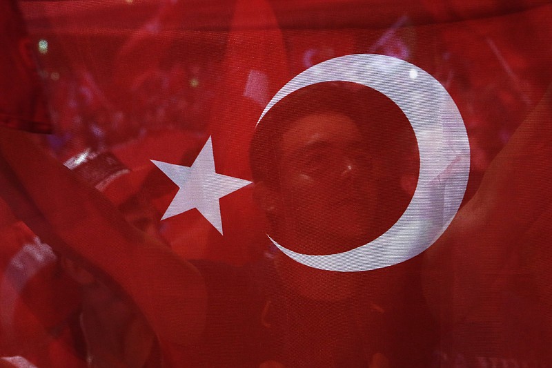 A man holds a Turkish flag during an anti coup rally at Taksim square in Istanbul, Tuesday, July 26, 2016. Turkey's polarized factions should learn from their mistakes and overcome their antagonism, the main opposition leader Kemal Kilicdaroglu said during an interview with The Associated Press.
