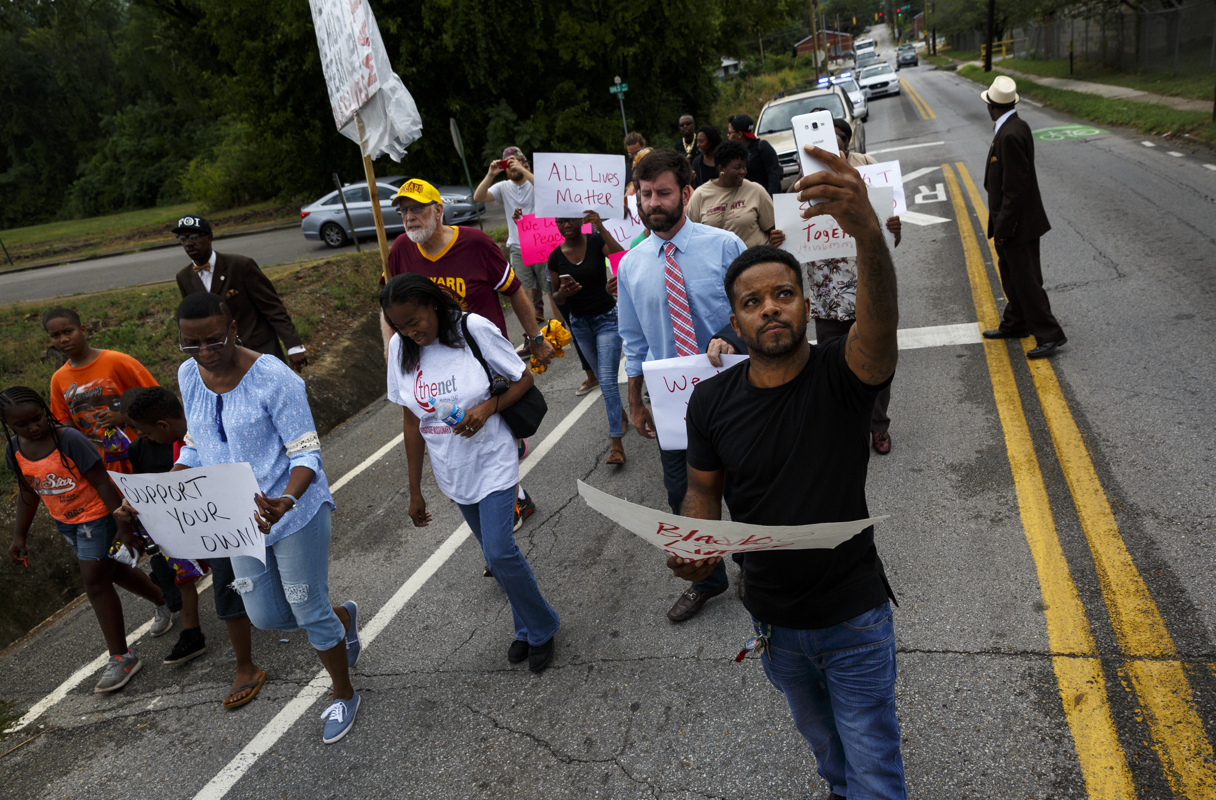 Demonstrators march along East 38th Street from South Chattanooga Recreation Center to Westside Baptist Church before a town hall meeting at the church to discuss race relations and poverty Thursday, July 28, 2016, in Chattanooga, Tenn. A panel of speakers took part in a discussion about race, poverty, and policing.