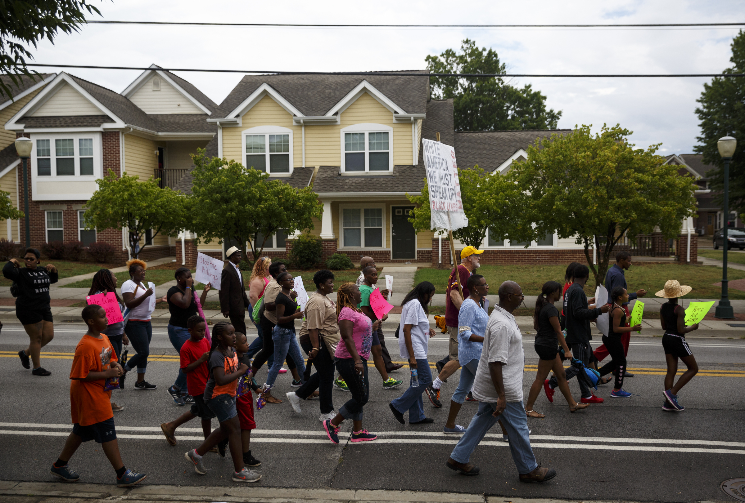 Demonstrators march along East 38th Street from South Chattanooga Recreation Center to Westside Baptist Church before a town hall meeting at the church to discuss race relations and poverty Thursday, July 28, 2016, in Chattanooga, Tenn. A panel of speakers took part in a discussion about race, poverty, and policing.