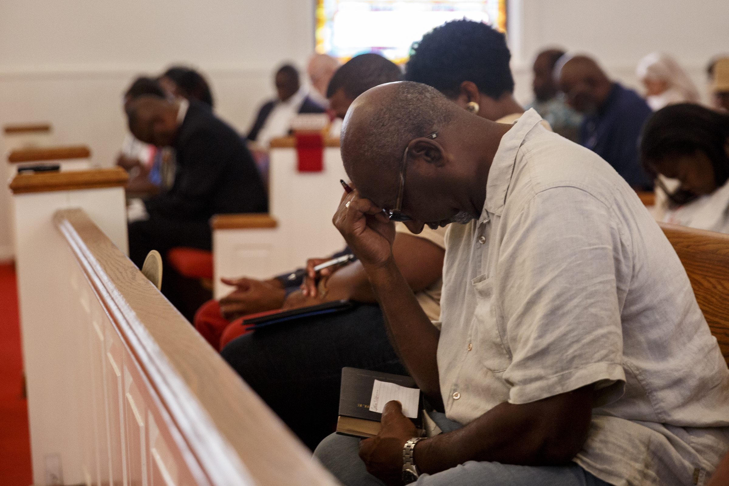 Theodore Taylor bows his head for a prayer before a town hall meeting to discuss race relations and poverty at Westside Baptist Church on Thursday, July 28, 2016, in Chattanooga, Tenn. A panel of speakers took part in a discussion about race, poverty, and policing.