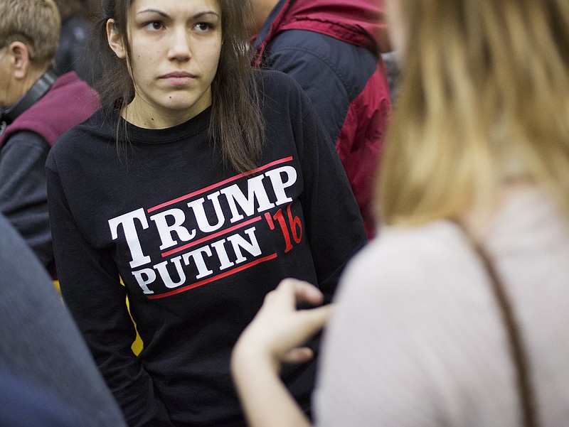 In this Sunday, Feb. 7, 2016 file photo, a woman wears a shirt reading 'Trump Putin '16' while waiting for Republican presidential candidate Donald Trump to speak at a campaign event at Plymouth State University in Plymouth, N.H. Donald Trump just keeps giving Russian President Vladimir Putin more reasons to hope he wins the U.S. election, while raising serious questions about the Republican candidate's intentions toward the Kremlin. In his most recent outreach to Putin, Trump not only refused to condemn Russia's military takeover of Ukraine's Crimean Peninsula but said, if elected, he would consider recognizing it as Russian territory and lifting sanctions against Moscow. "We'll be looking at that. Yeah, we'll be looking," Trump told reporters on Wednesday, July 27, 2016.  (AP Photo/David Goldman, File)            