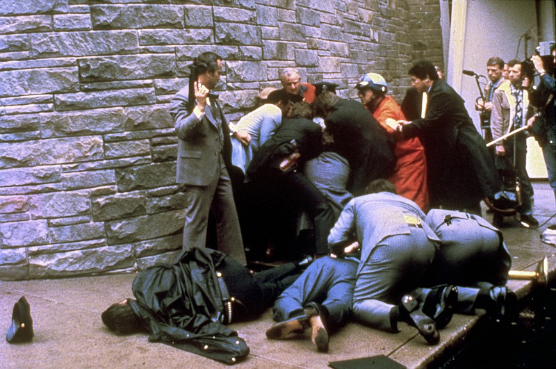 
              FILE - In this March 30, 1981 file photo, a U.S. secret service agent with an automatic weapon watches over James Brady, the president's secretary, after being wounded in an attempt on the life of President Ronald Reagan in Washington. A Washington, D.C. policeman, Thomas Delahanty, lies to the left after also being shot. John Hinckley Jr. shot four people outside a Washington hotel on March 30, 1981, but two of his victims understandably got most of the attention: President Ronald Reagan and his press secretary, James Brady. Former Secret Service agent Timothy McCarthy and former District of Columbia police officer Thomas Delahanty, both of whom took bullets to protect the president.  (AP Photo/Ron Edmonds, File)
            