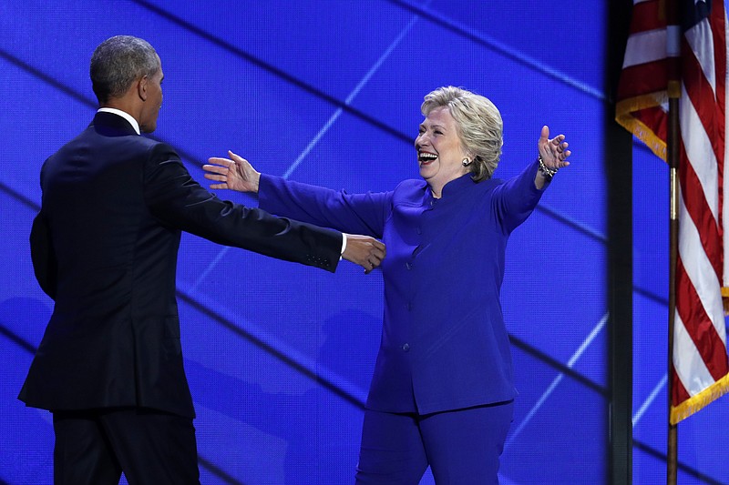 Democratic presidential nominee Hillary Clinton reaches for President Barack Obama as she steps on stage after President Obama's speech during the third day of the Democratic National Convention in Philadelphia , Wednesday, July 27, 2016. (AP Photo/J. Scott Applewhite)
