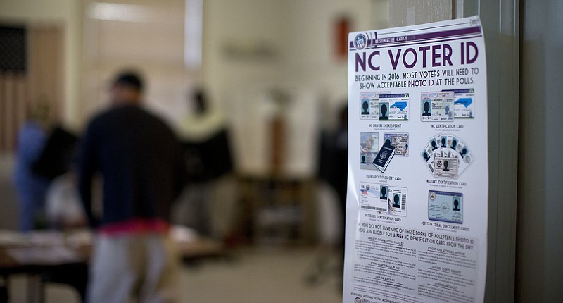 
              This photo taken March 15, 2016, shows a NC Voter ID rules posted at the door of the voting station at the Alamance Fire Station in Greensboro, N.C. A federal appeals court on Friday, July 29, 2016,  blocked a North Carolina law that required voters to produce photo identification and follow other rules disproportionately affecting minorities, finding that the law was intended to make it harder for blacks to vote in the presidential battleground state. (Andrew Krech/News & Record via AP)
            