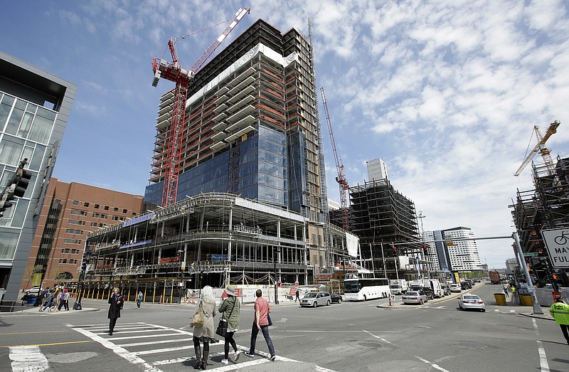 
              In this Thursday, May 19, 2016, photo, passers-by walk near the construction site a high-rise building in Boston. On Friday, July 29, 2016, the Commerce Department issues the first estimate of how the U.S. economy performed in the April-June quarter. (AP Photo/Steven Senne)
            