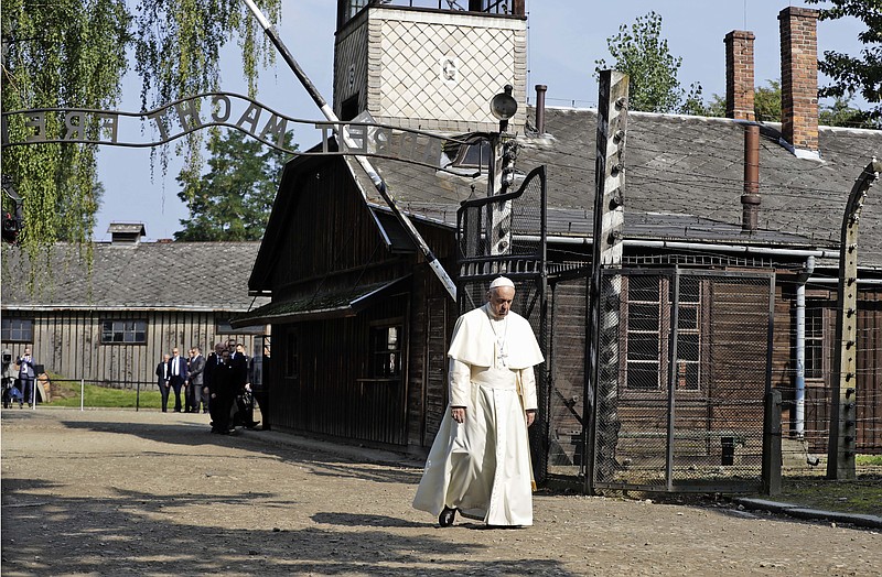 Pope Francis walks through the gate of the former Nazi German death camp of Auschwitz in Oswiecim, Poland, Friday, July 29, 2016. Pope Francis paid a somber visit to the Nazi German death camp of Auschwitz-Birkenau Friday, becoming the third consecutive pontiff to make the pilgrimage to the place where Adolf Hitler's forces killed more than 1 million people, most of them Jews.