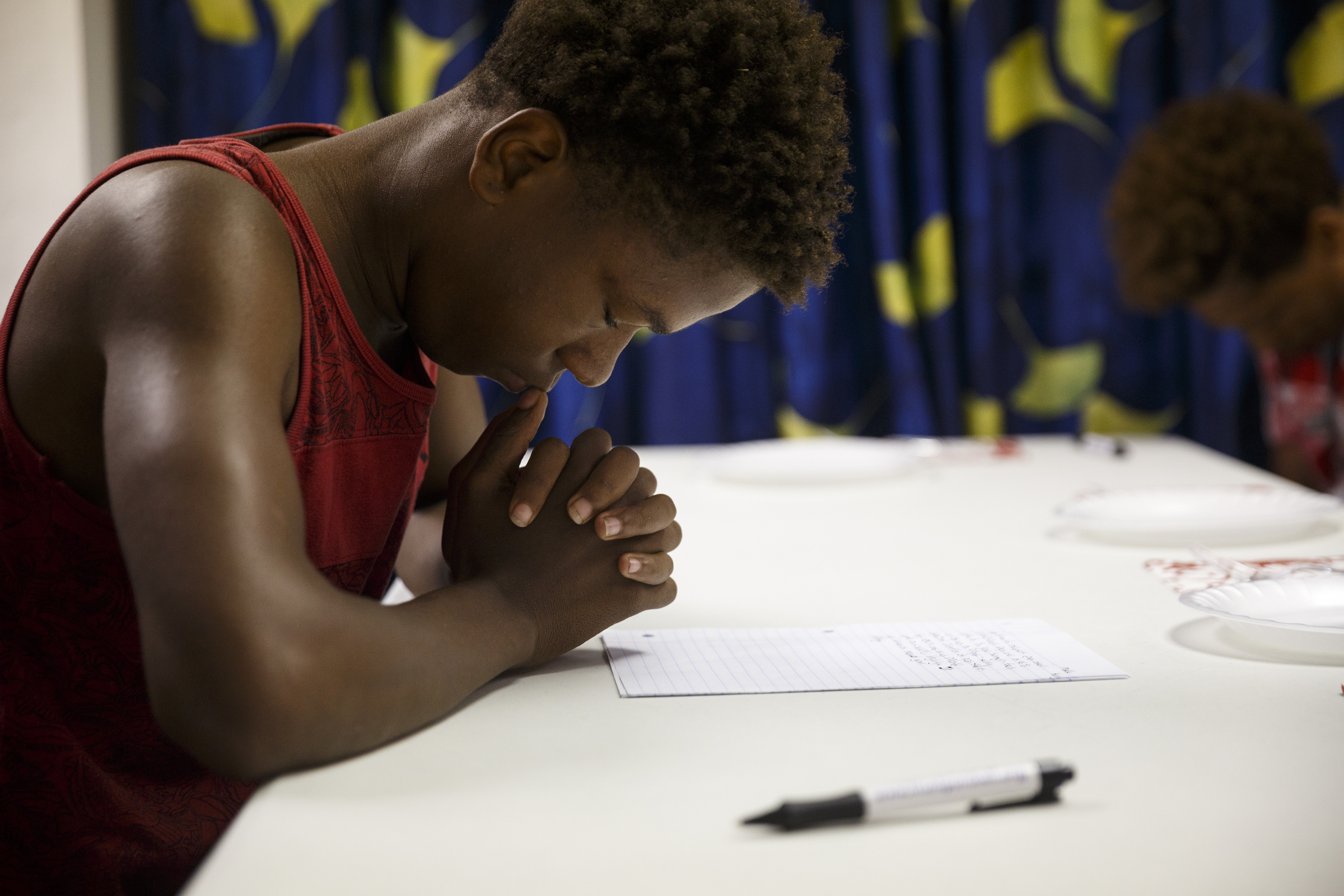 Malik Henry prays at a celebration luncheon at Front Porch Alliance on Friday, July 29, 2016, in Chattanooga, Tenn. Henry was among 5 students who were paid $10 an hour over the summer to learn money management and lawn work.