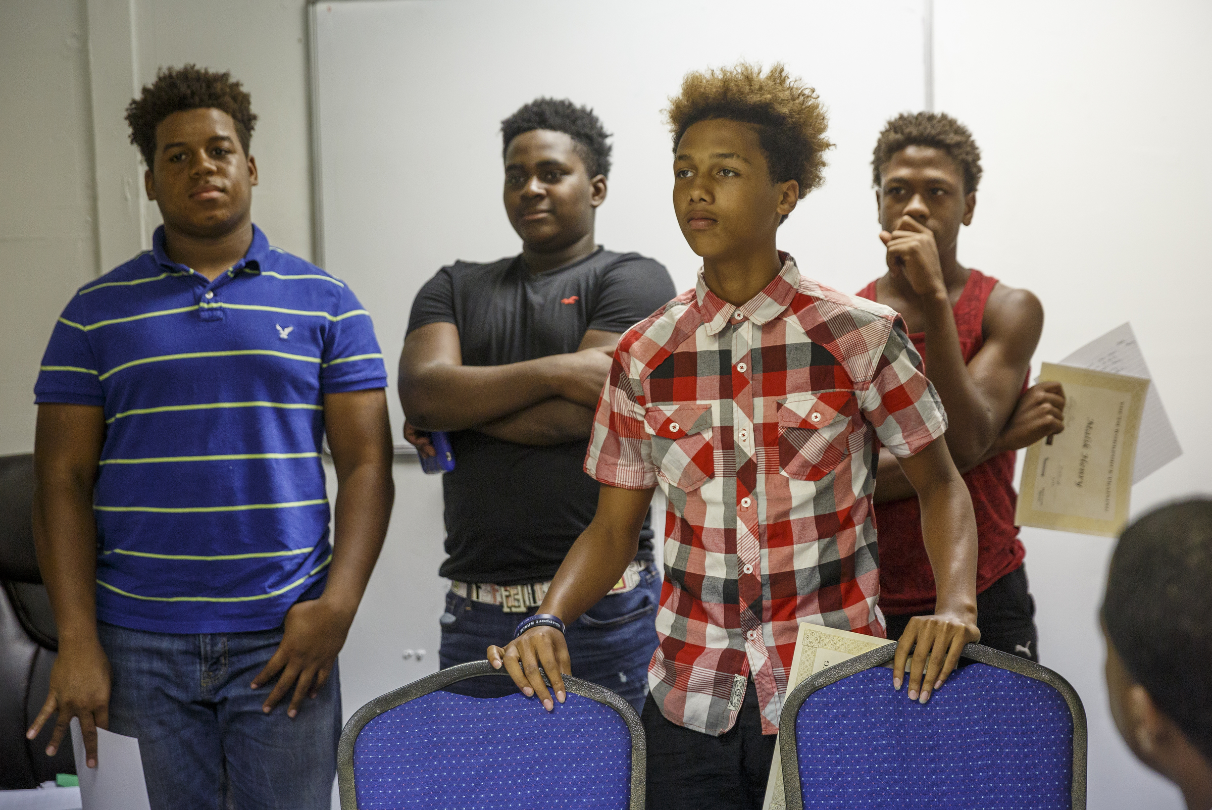Austin Lewis, Javontae Harris, Devonte Wigfall, and Malik Henry, from left, receive certificates at a celebration luncheon at Front Porch Alliance on Friday, July 29, 2016, in Chattanooga, Tenn. They were among 5 students who were paid $10 an hour over the summer to learn money management and lawn work.