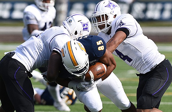 UTC's James Stoval is tackled by Furman's Trey Robinson, left, and Richard Hayes III at Finley Stadium on Saturday, October 10, 2015.