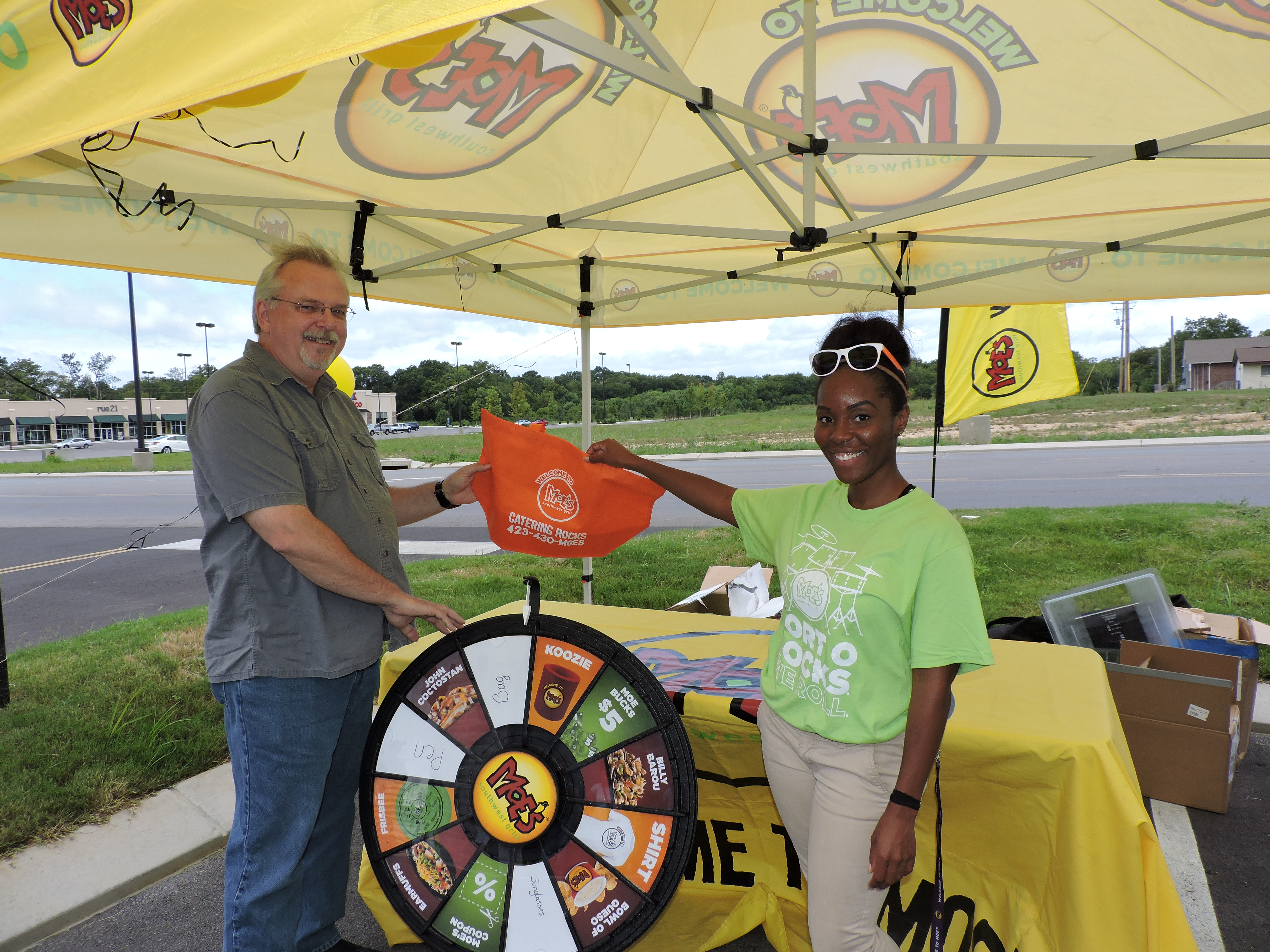 Bill Newman, of Ringgold, spins the Moe's Southwest Grill wheel to win a prize. Moe's Southwest Grill brand ambassador Meredith Seay hands him a goody bag for taking the time to spin the wheel.