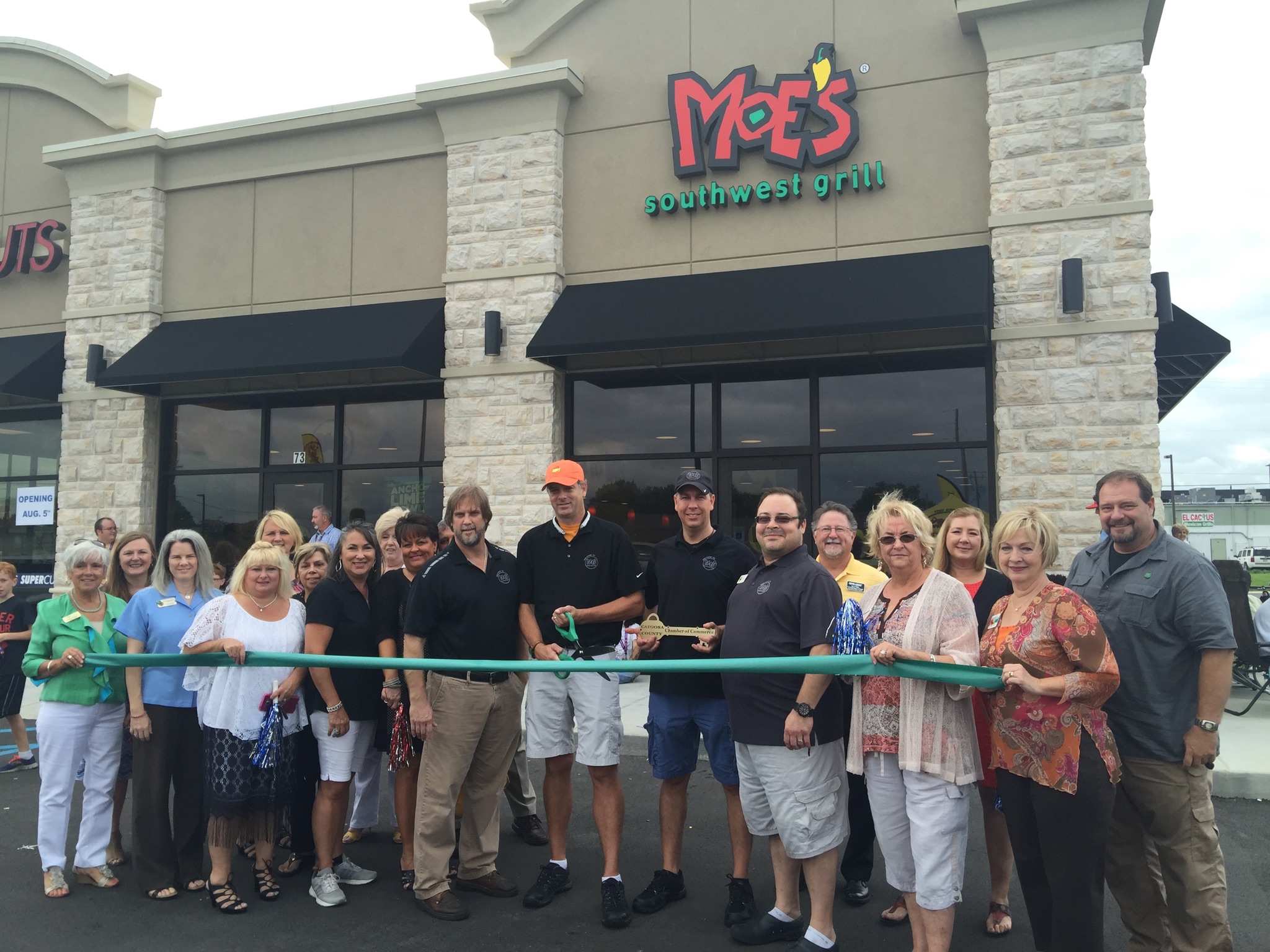 The staff of the new Moe's in Fort Oglethorpe cuts the ribbon with the Catoosa County Chamber of Commerce on opening day.