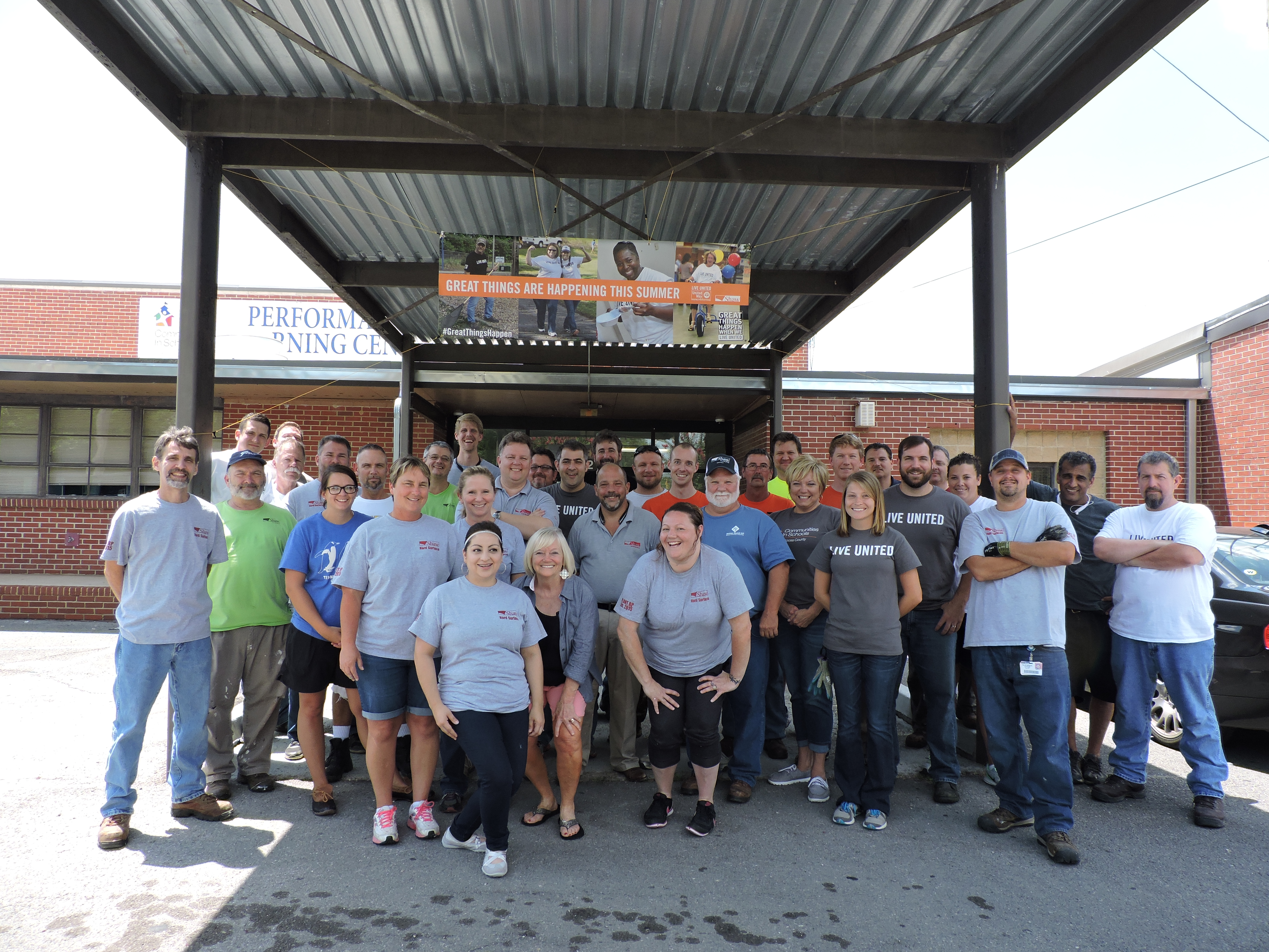 A team of 40 Shaw Industries volunteers takes a break from working together to lay flooring and paint walls at the Performance Learning Center in Fort Oglethorpe. The PLC is an alternative school for local students who struggle in a traditional class setting.