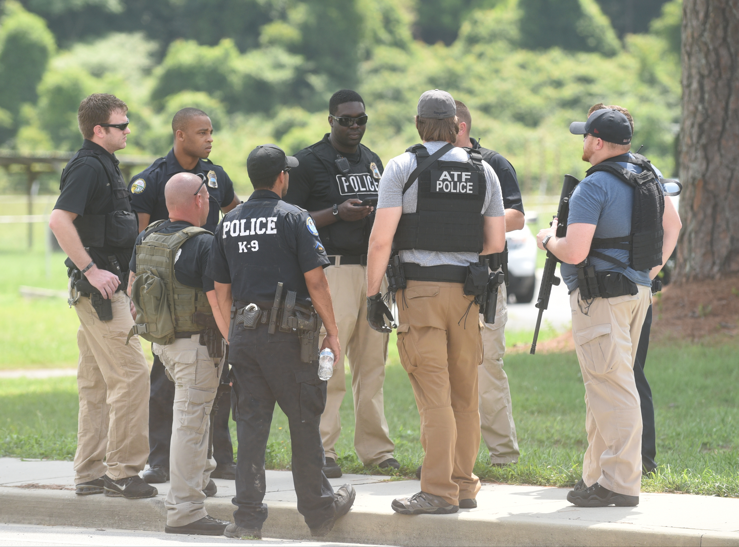 Officers are gathered on Old Lee Highway near the intersection of Apison Pike Monday, August 1, 2016 while searching for a man who fled police.