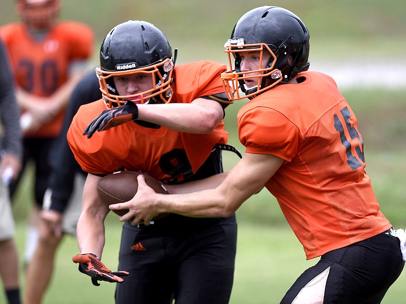 Fullback Garrett Raulston (9) takes the handoff from quarterback Hogan Holland (15).  The South Pittsburg Pirates football team practiced, Thursday July 30, 2016, in preparation for the coming season.  