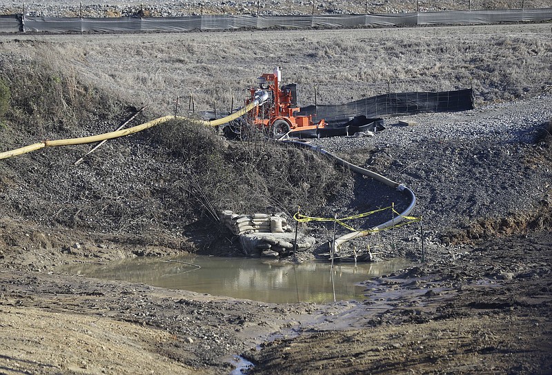 
              FILE - In this Jan. 14, 2016 file photo, a drainage pipe that was the original culprit of the coal ash spill is seen at the Dan River Steam Station in Eden, N.C. North Carolina's top public health official acted unethically and possibly illegally by telling residents living near Duke Energy coal ash pits that their well water is safe to drink when it's contaminated with a chemical known to cause cancer, a state toxicologist said in sworn testimony.  (AP Photo/Gerry Broome, File)
            