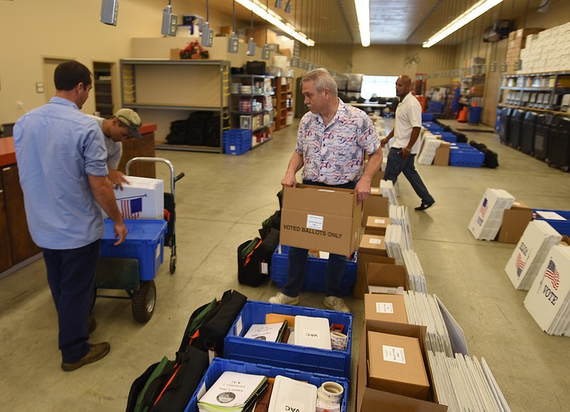 Darryl Orr, Darren Jones, Mark Parks and Ty Jacobs, from left, gather poll items to load into a car Wednesday, August 3, 2016 at the Election Commission on Amnicola Highway.