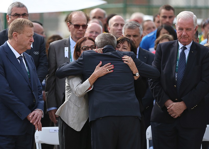 
              International Olympic Committee (IOC) President Thomas Bach, back to camera, embraces Ilana Romano, right, and Ankie Spitzer, widows of Israeli Olympic athletes killed by Palestinian gunmen at the 1972 Munich Olympics, during the inauguration of a memorial in their husbands' honor, ahead of the Summer Olympics in Rio de Janeiro, Brazil, Wednesday, Aug. 3, 2016. The International Olympic Committee (IOC) inaugurated the monument on Wednesday in memory of the 11 Israelis who were killed. (AP Photo/Edgard Garrido, Pool)
            