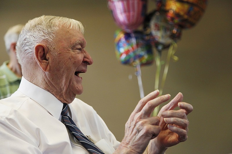 Charles Coolidge laughs and claps as friends and family finish singing for him at his 90th birthday celebration at Outdoor Chattanooga in 2011.