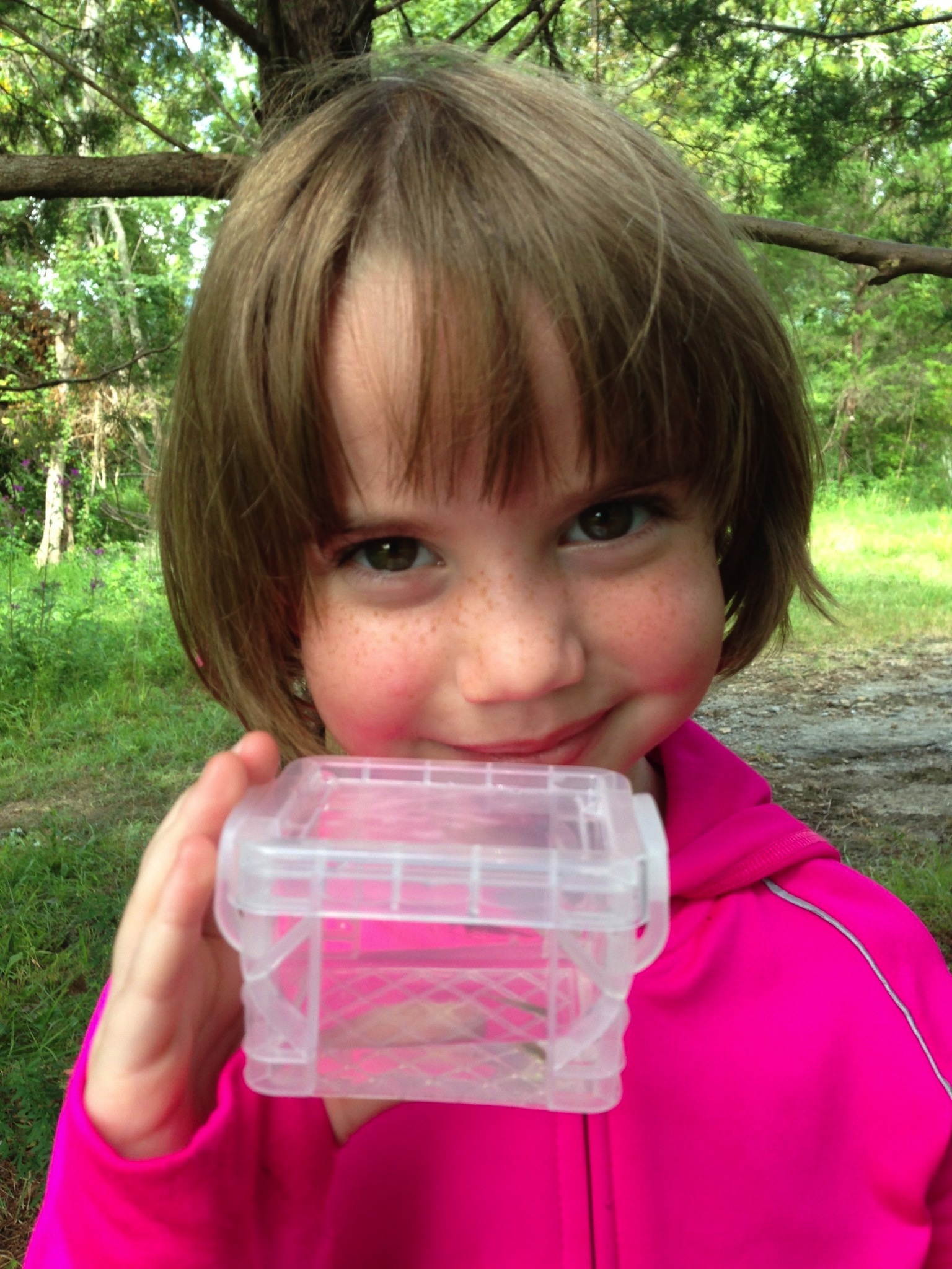 Cote Laughner holds up the minnow she caught in the creek at Wauhatchie School's forest kindergarten.