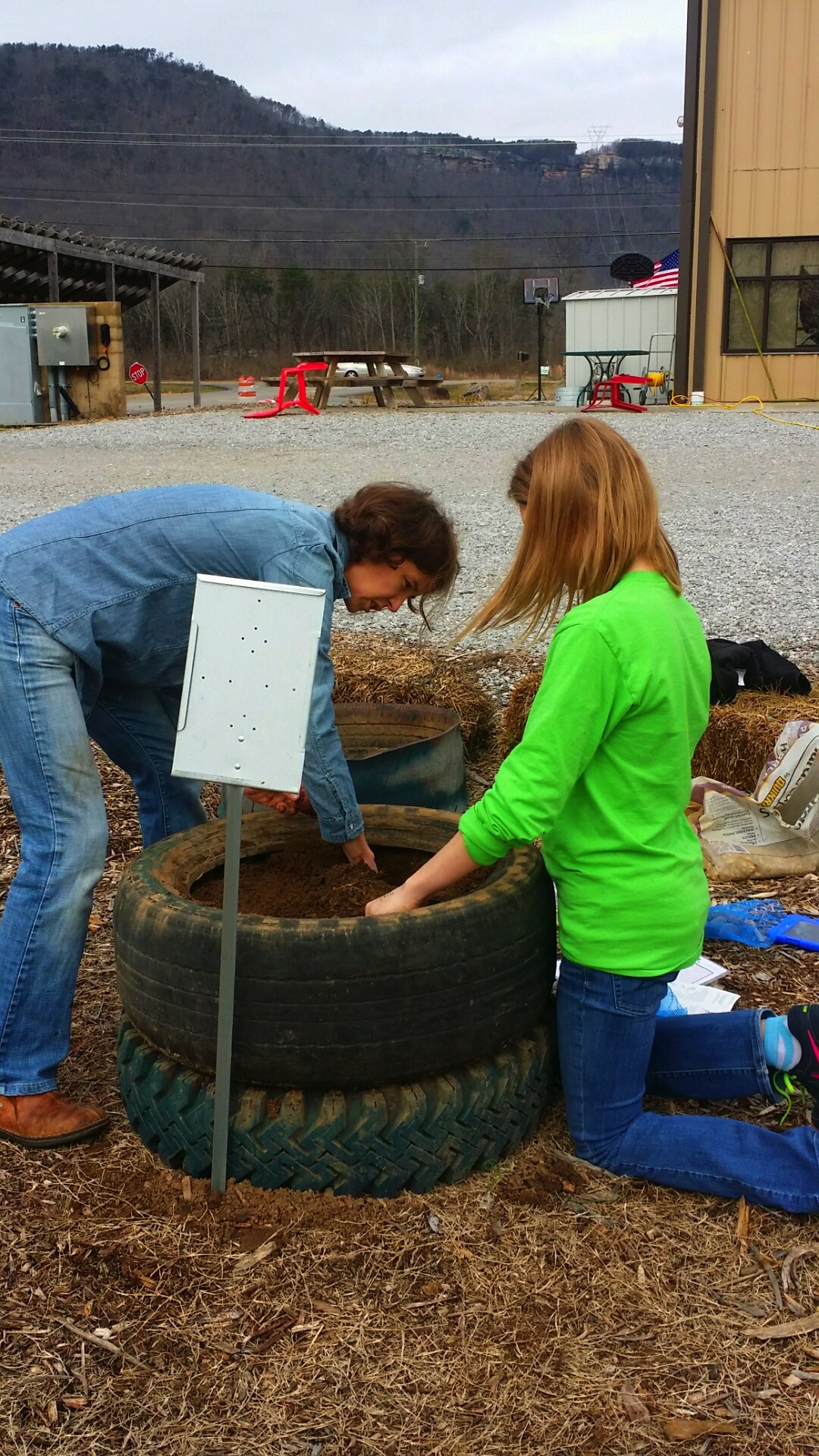 Ivy Academy science teacher Stephanie Kiefer, left, and sophomore Leslie Prifogle plant potatoes in the school's farm-to-school garden.