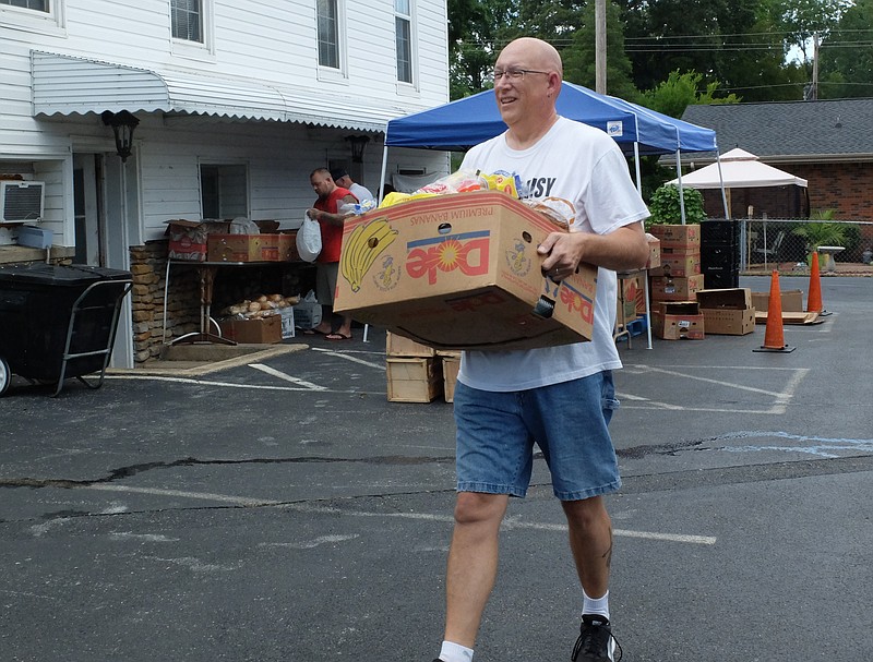 Pastor Todd Kingrea works to fill food bank orders on the lot at the Soddy United Methodist Church. Kingrea has written a book about Church Bullying.