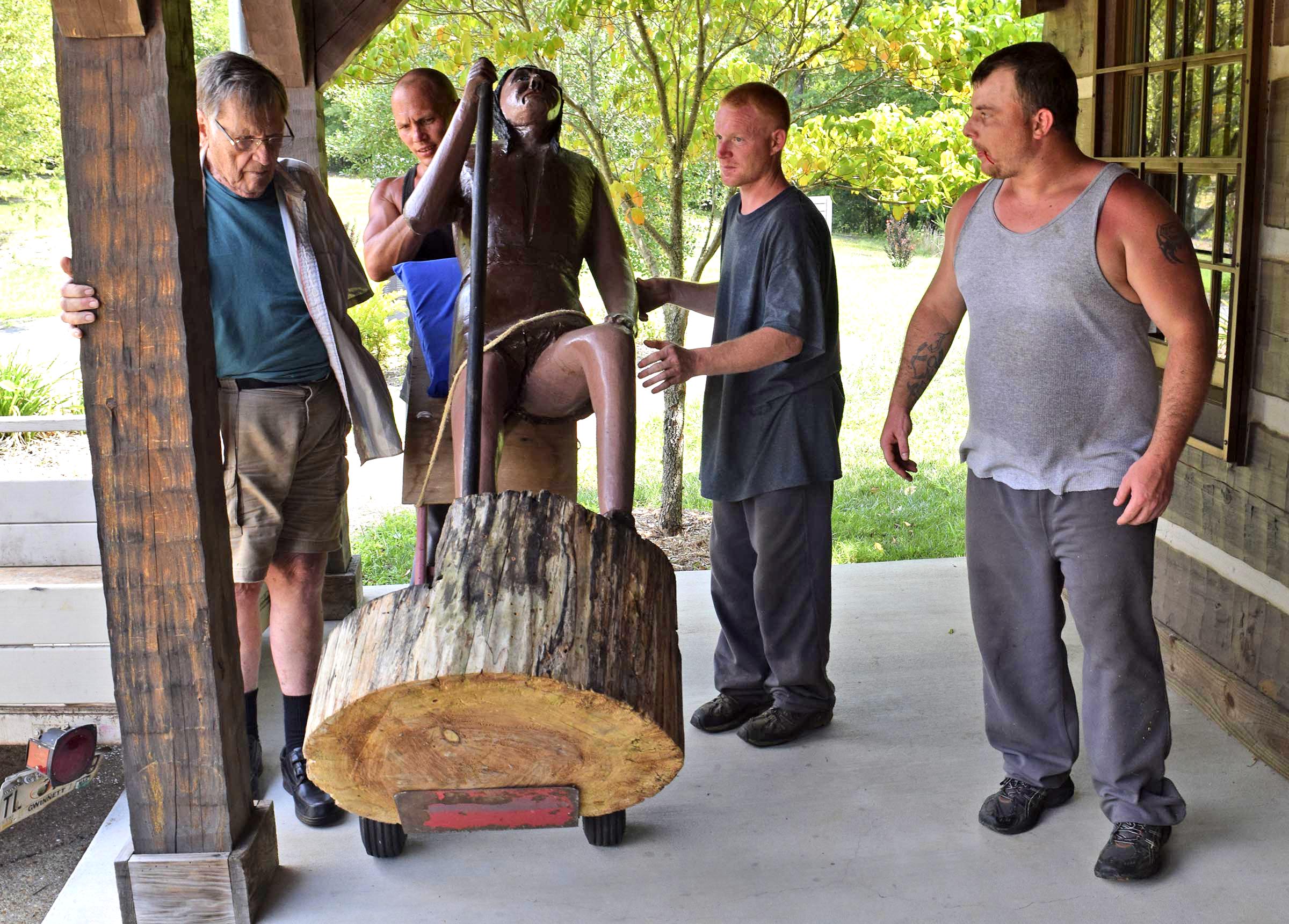 A team of Meigs County inmates unload a sculpture of early-1800s Cherokee interpreter John Spears carved by former resident Ray Hoskins, at left, that was donated this week to the Cherokee Removal Memorial Park. He and his wife, Shirley. Shirley Hoskins is the great-great-great-great granddaughter of Spears.