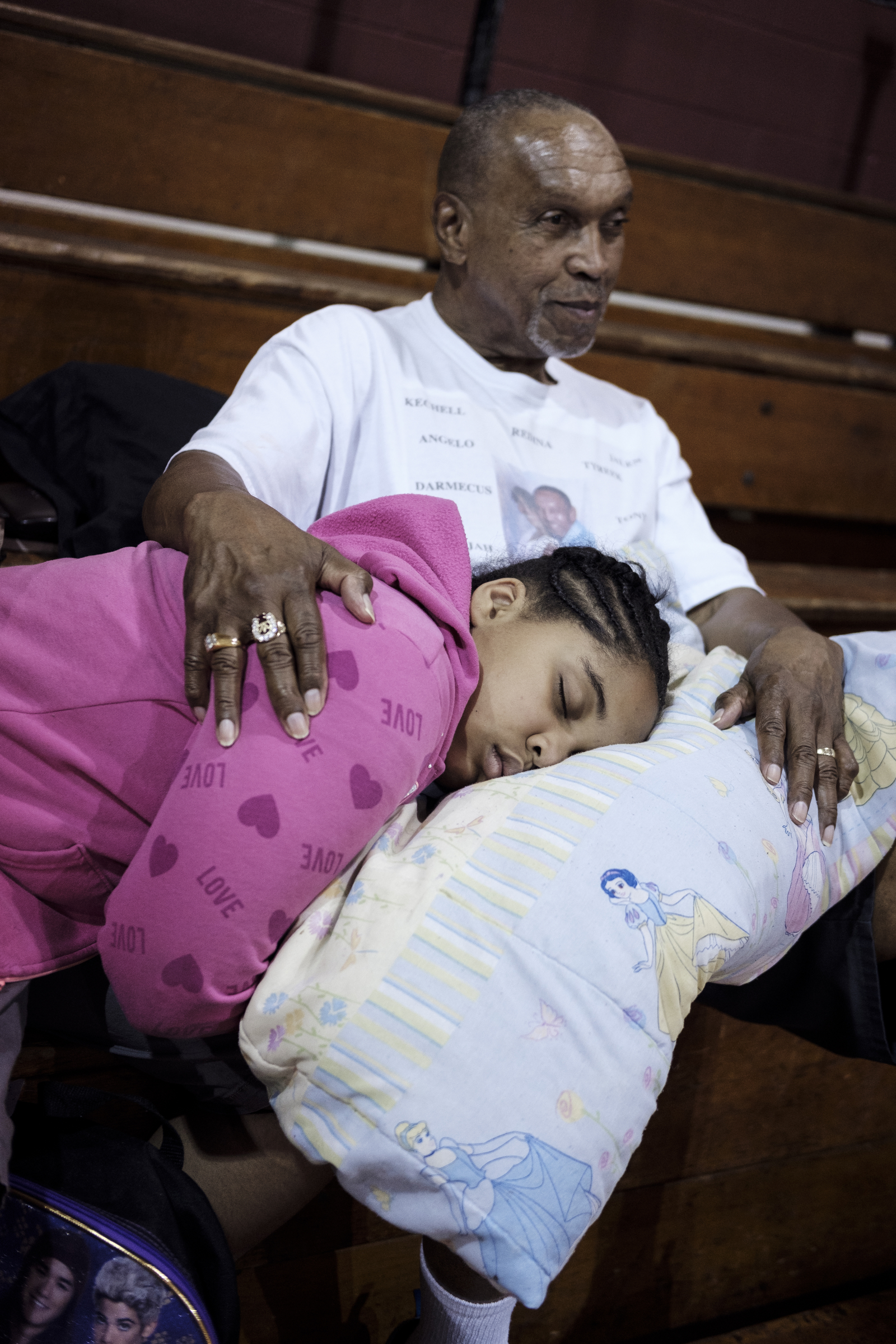 Brooklyn Clay naps on a pillow in the lap of her father, George Clay, before leaving for the Kids Across America camp from Hope for the Inner City on Saturday, July 23, 2016, in Chattanooga, Tenn. Chattanooga police officer Danny Jones took a group of inner-city youths to the Branson, Mo., Christian camp for the 2nd year in a row.