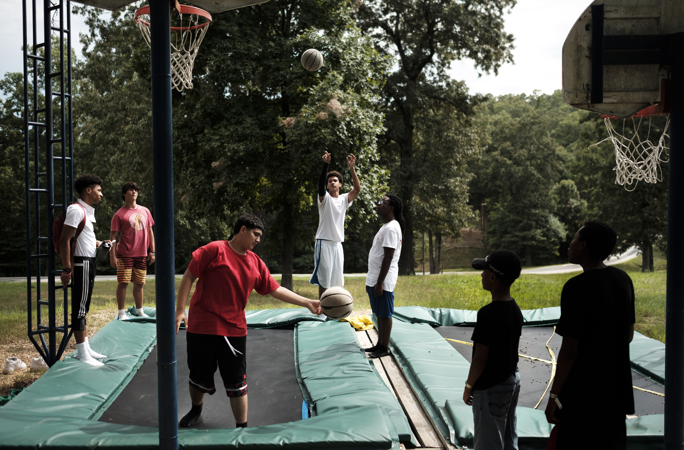 Kids shoot baskets at a trampoline basketball goal during an activity at the Kids Across America camp Tuesday, July 26, 2016, near Branson, Mo. The camp ministers to inner-city youths brought from across the country.