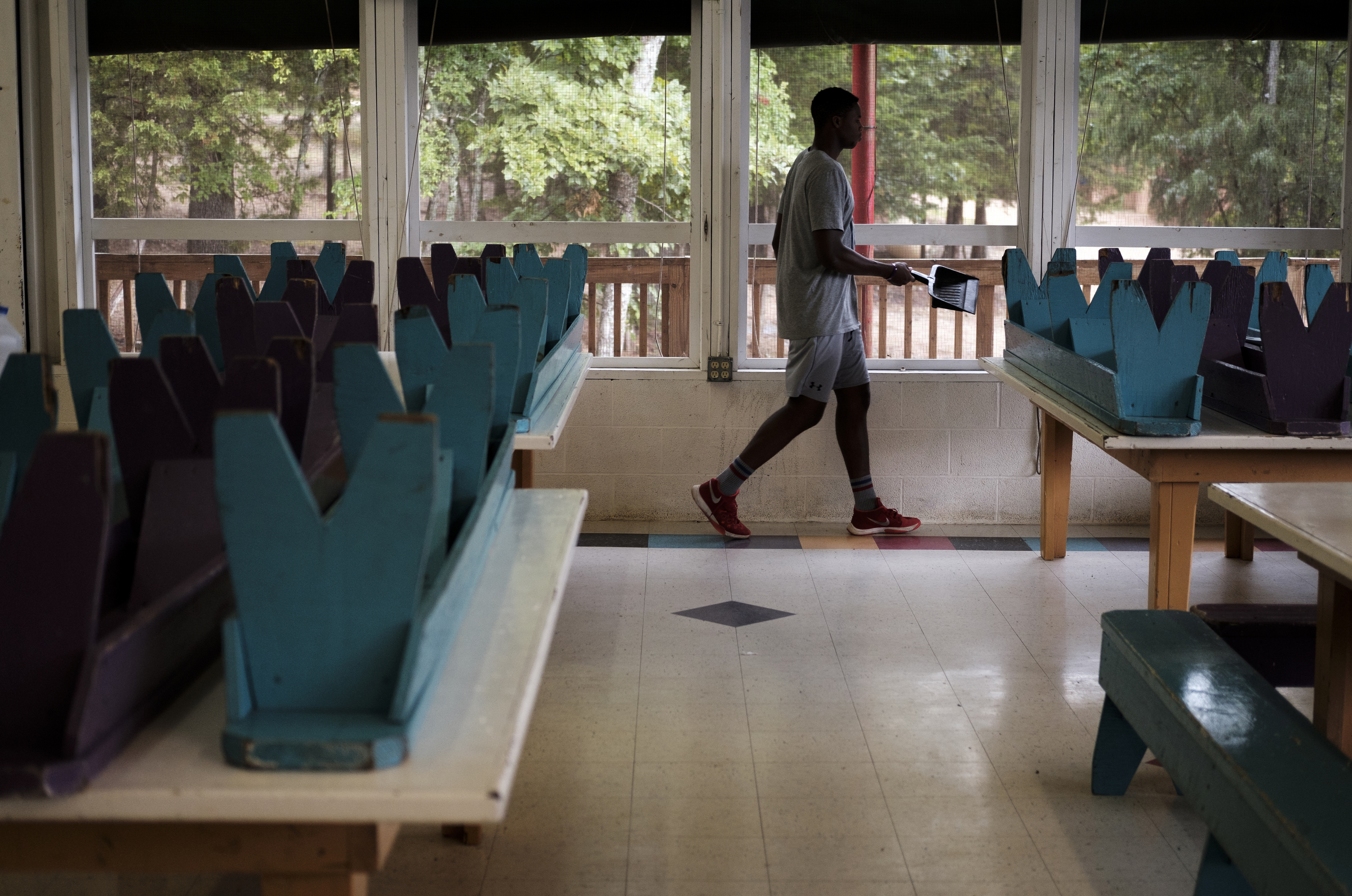 Cam Chambers puts away a dust pail after sweeping the floor at the end of breakfast at the Kids Across America camp Wednesday, July 27, 2016, near Branson, Mo. Chambers is one of many inner-city youths from Chattanooga brought to the camp by Chattanooga police officer Danny Jones.