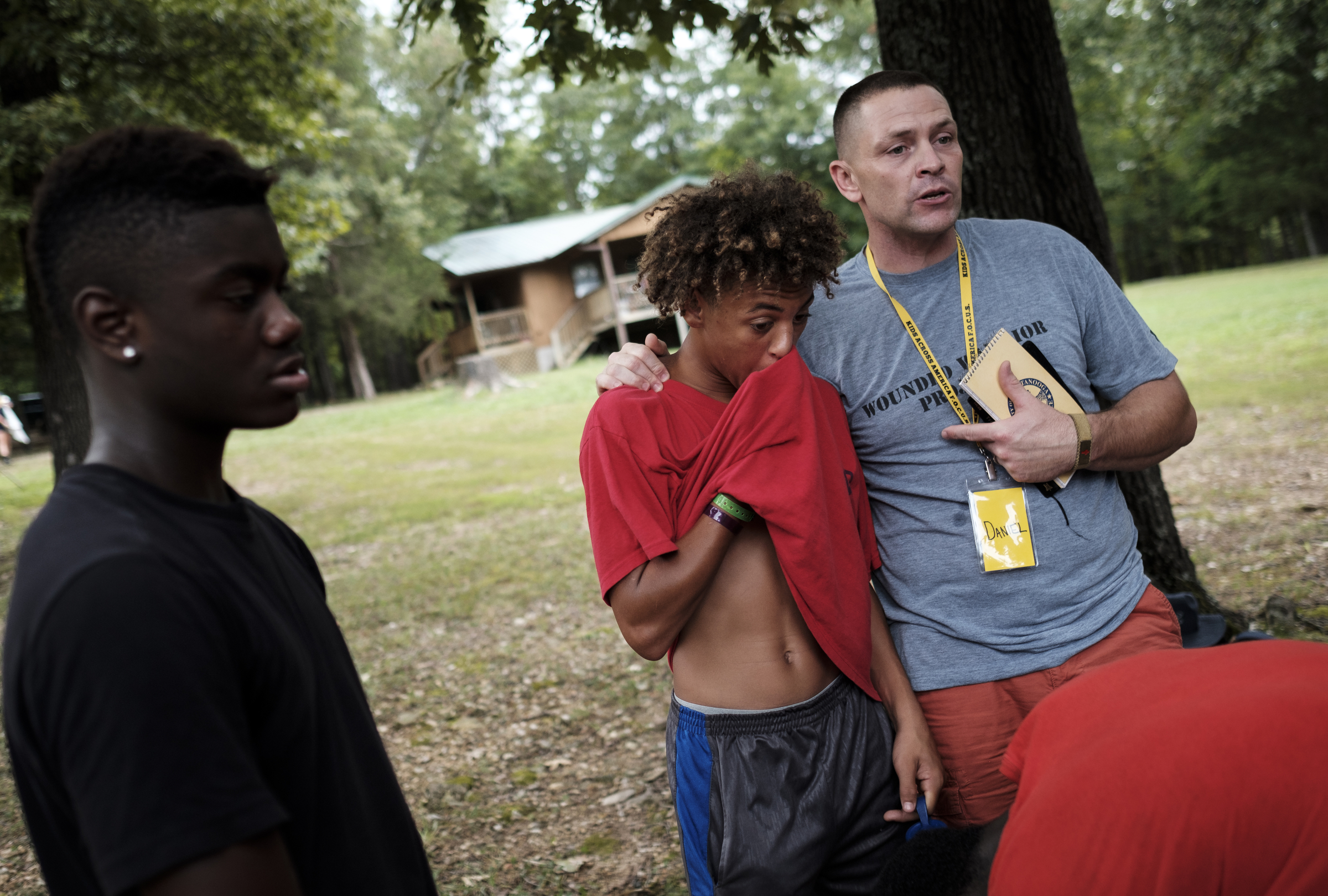 Chattanooga police officer Danny Jones puts his arm around Jesse Cowley, center, with Dai'Sean 