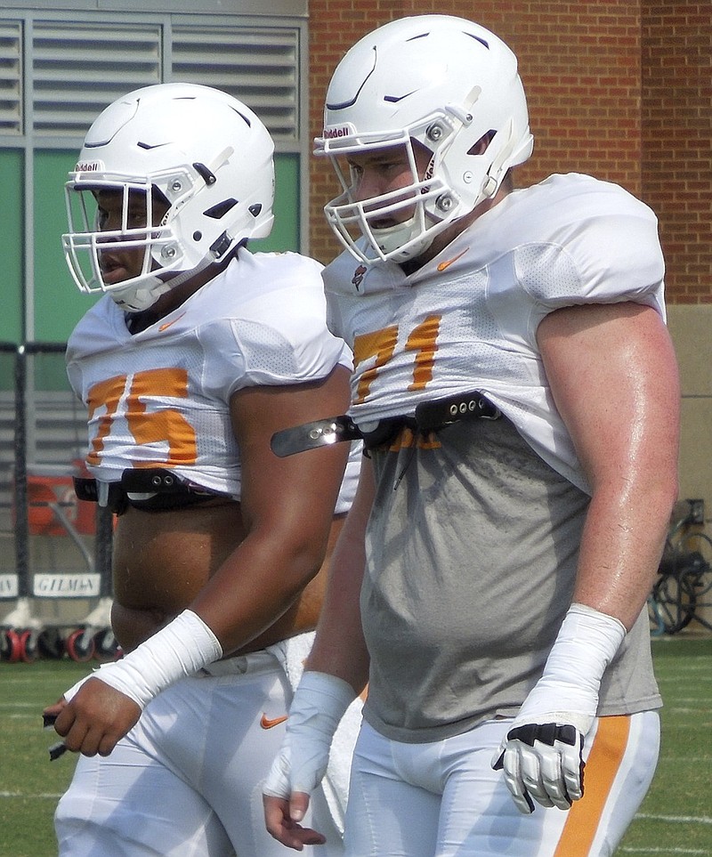 Dylan Wiesman, right, walks next to fellow offensive lineman Jashon Robertson during Tennessee's practice Saturday afternoon in Knoxville. Although most of the starters seem fairly set for the position group, its depth is pushing the No. 1 linemen to continue to work hard.