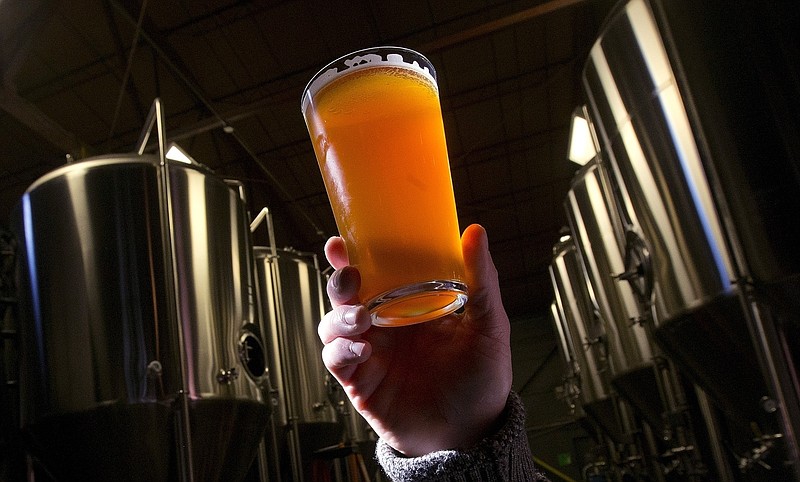 In this Dec. 11, 2013, file photo, brewer Stefano Daneri holding up a beer at Good People Brewing in Birmingham, Ala. Alabama's alcohol regulators want the name, address, age and phone number of everyone who buys beer in one of the state's craft breweries and takes it home to drink, a move that is raising concerns about privacy. he Alabama Alcoholic Beverage Control Board is considering a new rule that would require brewers to collect the personal information of anyone who purchases beer at a brewery for off-premise consumption.