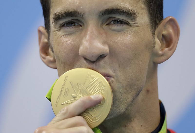 
              United States' Michael Phelps kisses his gold medal after the men's 4x100-meter freestyle final during the swimming competitions at the 2016 Summer Olympics, Monday, Aug. 8, 2016, in Rio de Janeiro, Brazil. (AP Photo/Michael Sohn)
            