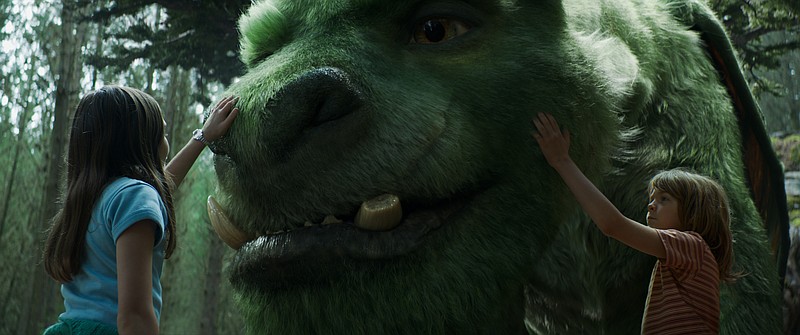 This image released by Disney shows Oona Laurence as Natalie, left, and Oakes Fegley as Pete, right, with Elliot the dragon, in a scene from "Pete's Dragon." (Disney via AP)