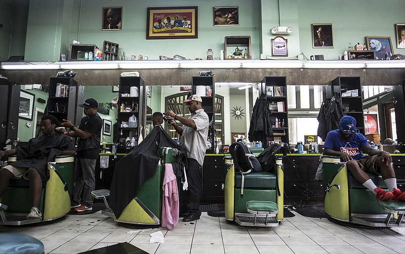 
              Customers get haircuts at Vintage the Barber Shop, on Tuesday, Aug. 9, 2016, in Atlanta. Swimmer Michael Phelps, of the United States, stopped by the shop before departing for the 2016 Summer Olympics in Rio de Janeiro, Brazil, and posted a selfie on his Instagram. (AP Photo/Ron Harris)
            