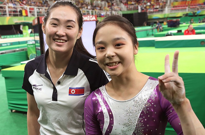 
              In this Sunday, Aug 7, 2016 photo, South Korean gymnast Lee Eun-ju, right, and her North Korean counterpart Hong Un Jong pose together for photographers during the artistic gymnastics women's qualification at the 2016 Summer Olympics in Rio de Janeiro, Brazil. Like dozens of athletes at the Rio Games, some competitors from North and South Korea have posed together for grinning selfies, which have then been posted to social media and documented by some of the hundreds of journalists here. These interactions are not strictly illegal in South Korea, but they are complicated by the Koreas’ long history of animosity and bloodshed. (Kim Do-hoon/Yonhap via AP) KOREA OUT
            