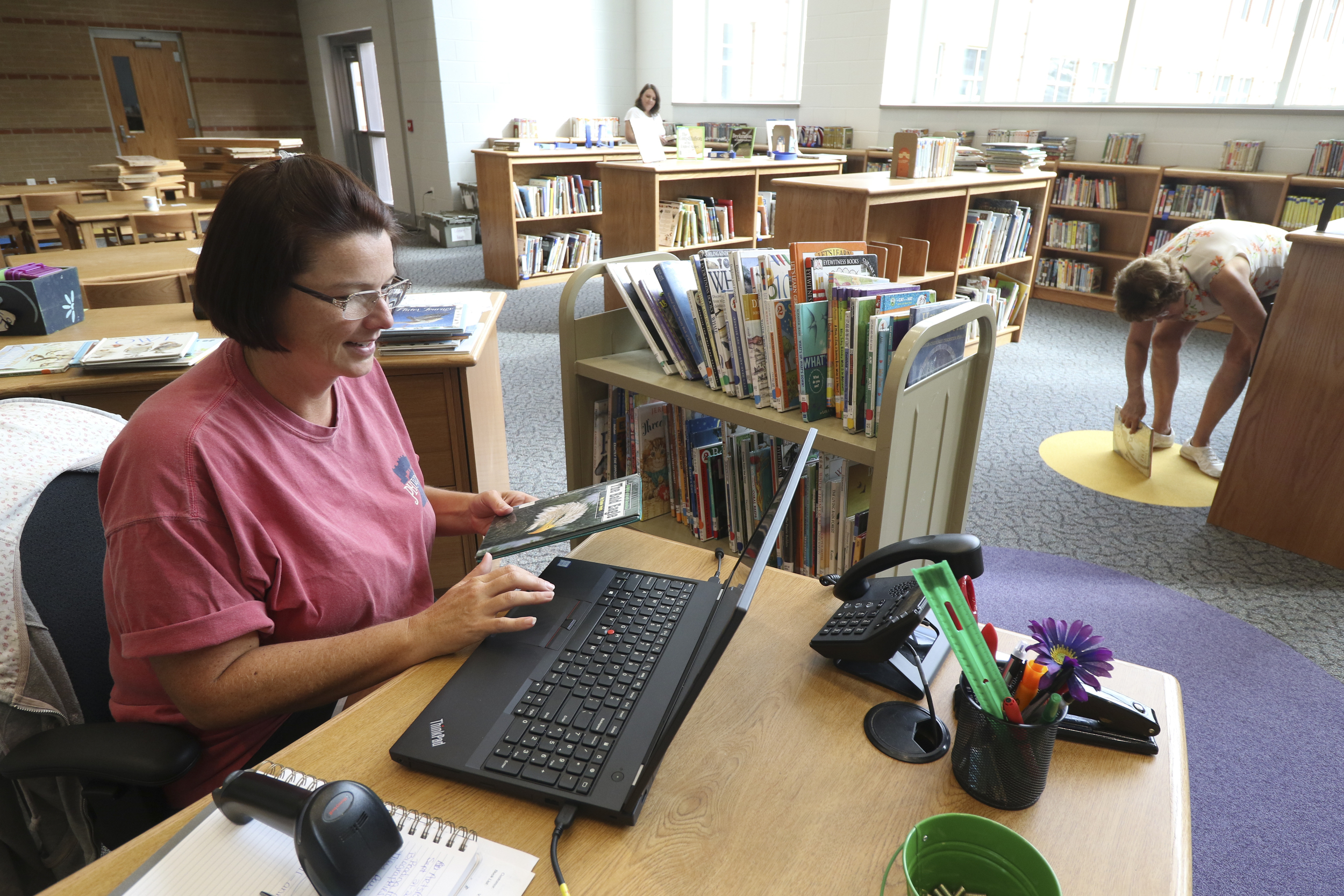 Staff Photo by Dan Henry / The Chattanooga Times Free Press- 8/9/16. Mary Poteet, left, checks in books while setting up the media center at the new Middle Valley Elementary School on Tuesday, August 9, 2016.