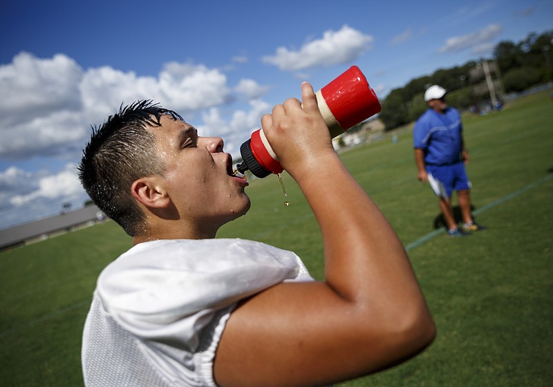 Gordon Central High School football player Abraham Reyes takes a drink during practice Wednesday afternoon at the school. The GHSA and TSSAA both have strict guidelines intended to keep athletes safe when working out in the summer heat.