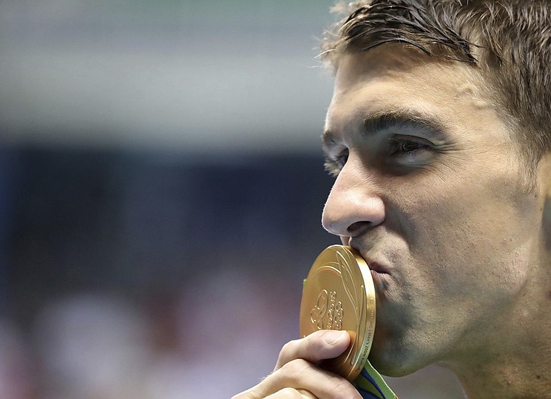 American swimmer Michael Phelps celebrates with his gold medal after winning the 200-meter butterfly Tuesday night in Rio de Janeiro.
