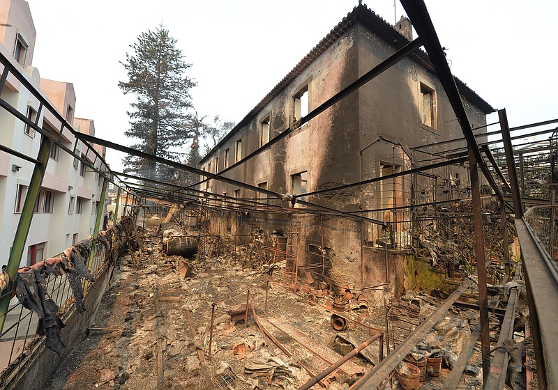 
              Debris litters the remains of a burnt building in Funchal, the capital of Portugal's Madeira island Wednesday, Aug. 10 2016. The building belonging to a flower-producing company was caught in the forest fires that are raging in Madeira and have forced the evacuation of more than 1,000 residents and tourists. (AP Photo/Helder Santos)
            