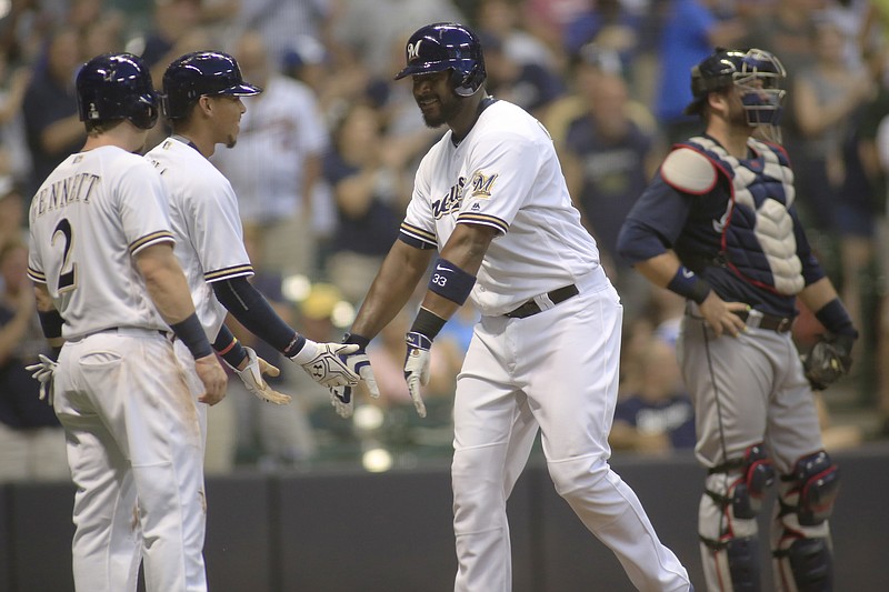 Milwaukee Brewers' Chris Carter is congratulated by Orlando Arcia, left rear, and Scooter Gennett after hitting a three-run home run against the Atlanta Braves during the third inning of a baseball game Wednesday, Aug. 10, 2016, in Milwaukee.