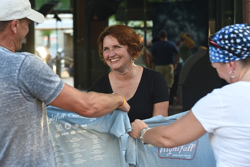 Carla Pritchard makes the decisions for the Nightfall Series in Miller Plaza and is seen here selling T-shirts on a recent Friday night concert.