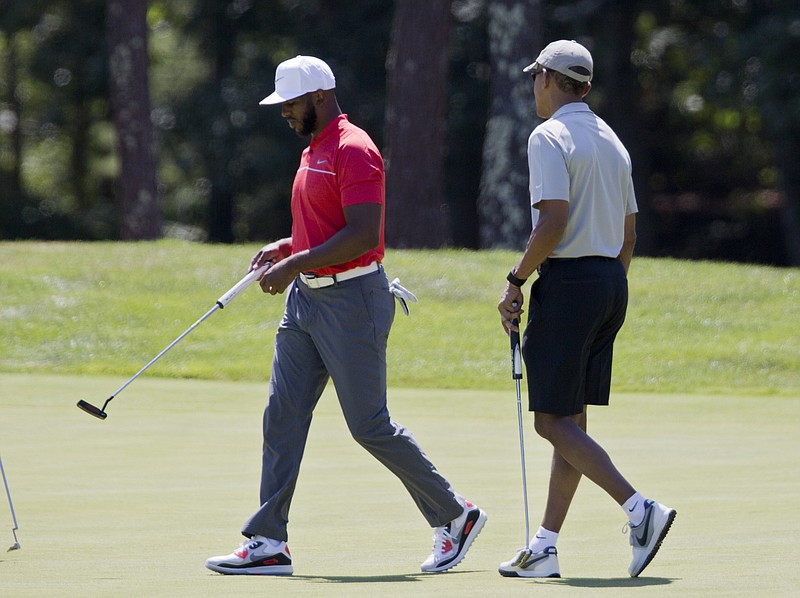 
              President Barack Obama and Los Angeles Clippers point guard Chris Paul walk on the first green during a round of golf at Farm Neck Golf Course in Oak Bluffs, Mass., on Martha's Vineyard, Sunday, Aug. 7, 2016. The president and his family are vacationing on the Massachusetts island of Martha's Vineyard. (AP Photo/Manuel Balce Ceneta)
            