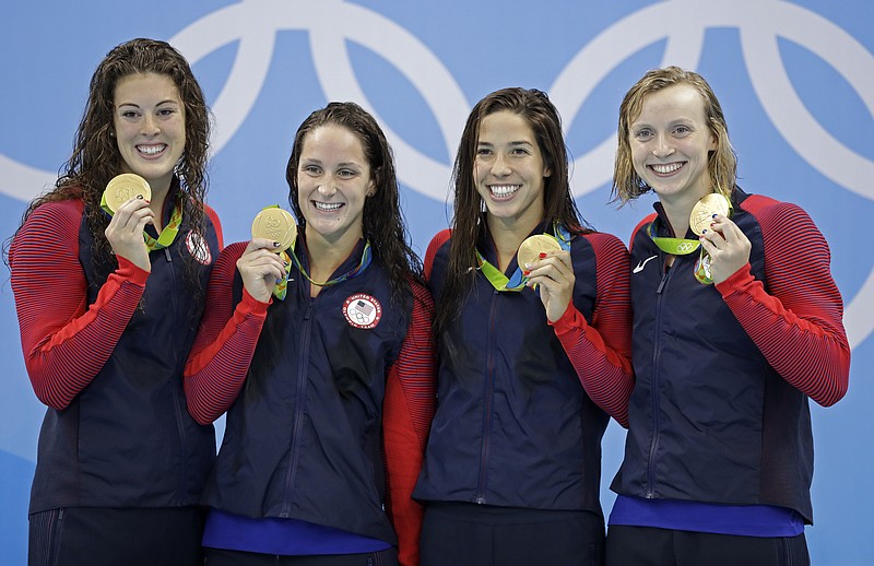 United States' Allison Schmitt, Leah Smith, Maya DiRado and Katie Ledecky, from left, hold up their gold medals during the women's 4 x 200-meter freestyle relay medals ceremony during the swimming competitions at the 2016 Summer Olympics, Thursday, Aug. 11, 2016, in Rio de Janeiro, Brazil. 