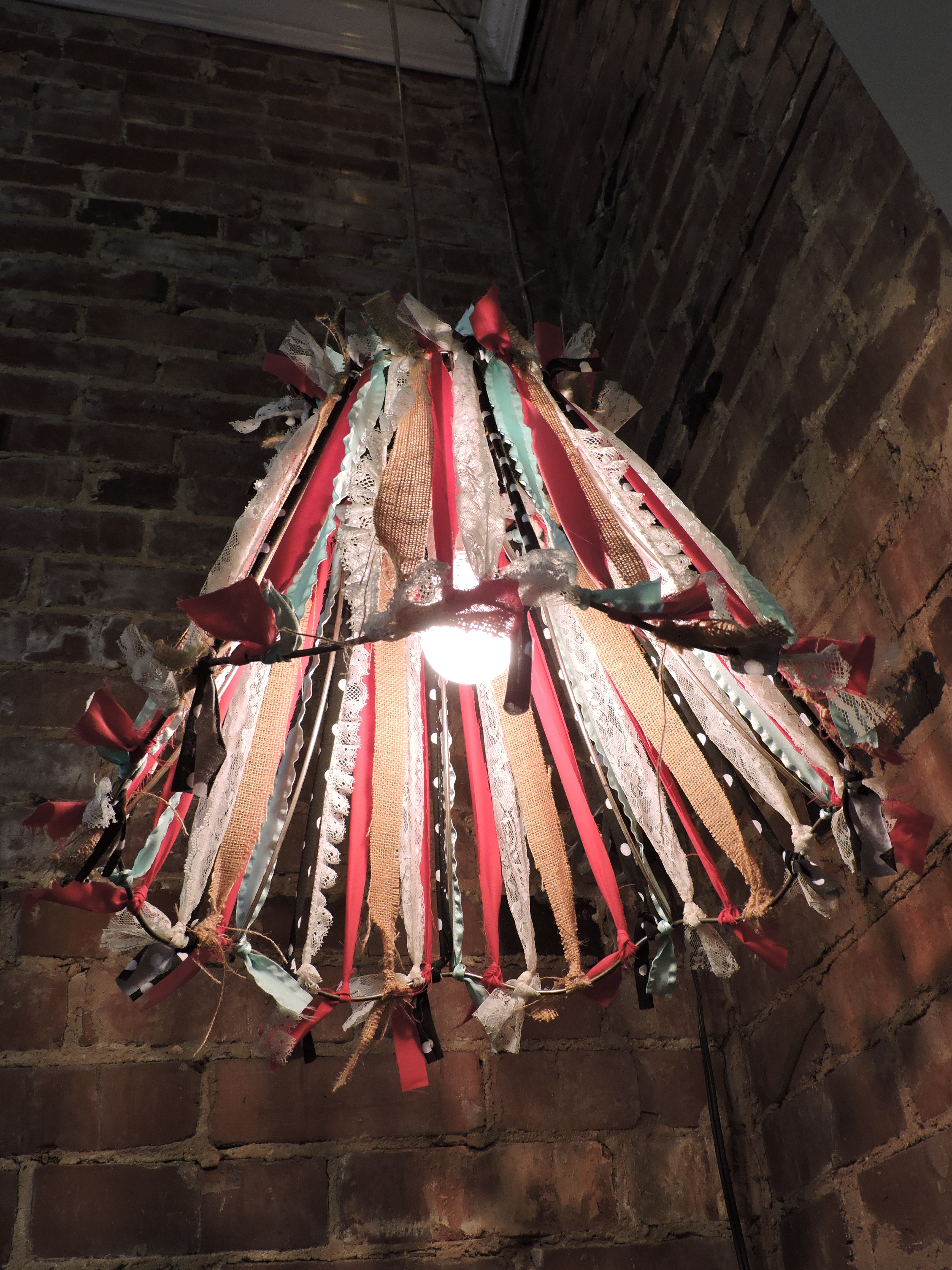 This repurposed lamp shade utilizes strips of various colors of cloth to create a unique crafty look. The shade was designed by Red Barn Designs co-owner Jenna Stevens.