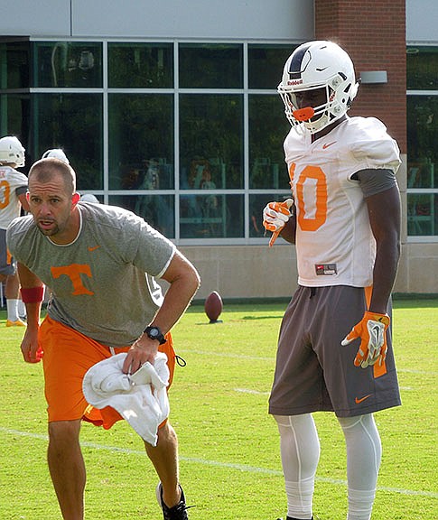 Vols receiver Tyler Byrd looks on as receivers coach Zach Azzanni teaches a technique during a practice Tuesday in Knoxville.